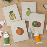 The four finished Pear Peach Pineapple mini canvases laid out on a table
