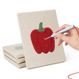 Hand punching one of the Pepper and Garlic mini canvases