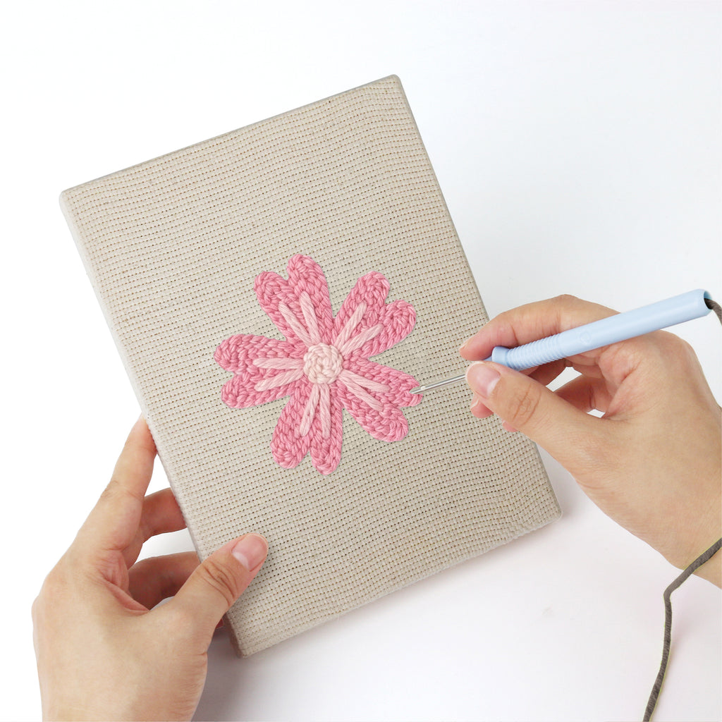Punching a Pink Blossom Heads mini canvas with the punch needle