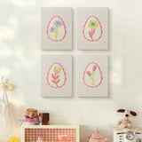 The four Pink Egg Posies mini canvases on a wall above a shelf