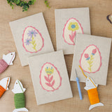 The four finished Pink Egg Posies mini canvases laid out on a table