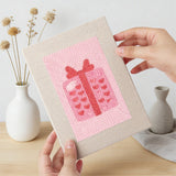 Hand holding a finished Pink Love Tokens mini canvas