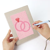 Punching a Pink Love Tokens mini canvas with the punch needle