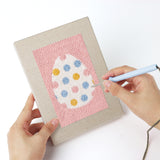 Punching a Pink Pastel Eggs mini canvas with the punch needle