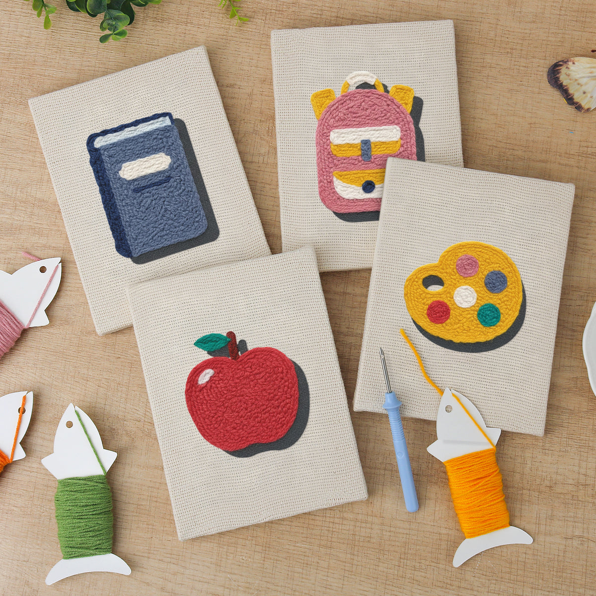 The four finished Pink School Backpack mini canvases laid out on a table