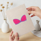 Hand holding a finished Pretty Pink Bras mini canvas