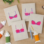 The four finished Pretty Pink Bras mini canvases laid out on a table