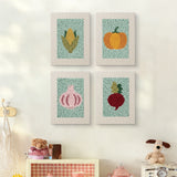 The four Pumpkin and Corn mini canvases on a wall above a shelf