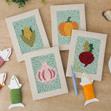 The four finished Pumpkin and Corn mini canvases laid out on a table
