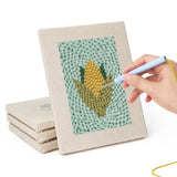 Hand punching one of the Pumpkin and Corn mini canvases