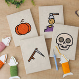The four finished Pumpkin and Skull mini canvases laid out on a table
