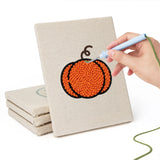 Hand punching one of the Pumpkin and Skull mini canvases