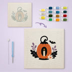 Pumpkin Candle Lantern canvas before and after punching, with the threads and tools