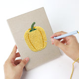 Punching a Pumpkin Pepper Patch mini canvas with the punch needle