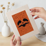 Hand holding a finished Pumpkin Scowls mini canvas