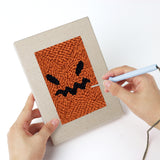 Punching a Pumpkin Scowls mini canvas with the punch needle