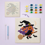 Pumpkin Witch in Flight canvas before and after punching, with the threads and tools