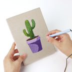 Punching a Purple Pot Cacti mini canvas with the punch needle