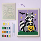 Raccoon Trick-or-Treater canvas before and after punching, with the threads and tools