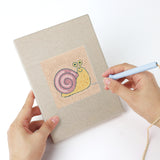 Punching a Rainbow and Ladybug mini canvas with the punch needle