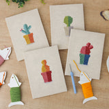 The four finished Rainbow Pot Cacti mini canvases laid out on a table