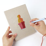 Punching a Rainbow Pot Cacti mini canvas with the punch needle