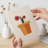 Hand holding a finished Red Daisy Pots mini canvas