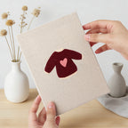 Hand holding a finished Red Heart Sweaters mini canvas