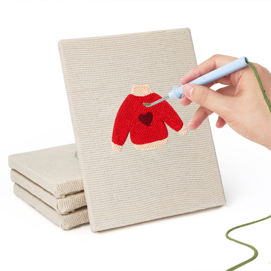 Hand punching one of the Red Heart Sweaters mini canvases
