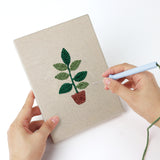 Punching a Red Pot Palms mini canvas with the punch needle