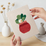 Hand holding a finished Red Pot Posies mini canvas