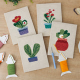 The four finished Red Pot Posies mini canvases laid out on a table