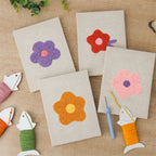 The four finished Retro Flower Heads mini canvases laid out on a table