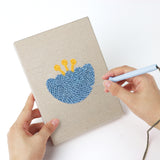 Punching a Retro Flower Shapes mini canvas with the punch needle