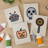 The four finished Robot and Lollipop mini canvases laid out on a table