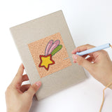 Punching a Rocket and Saucer mini canvas with the punch needle
