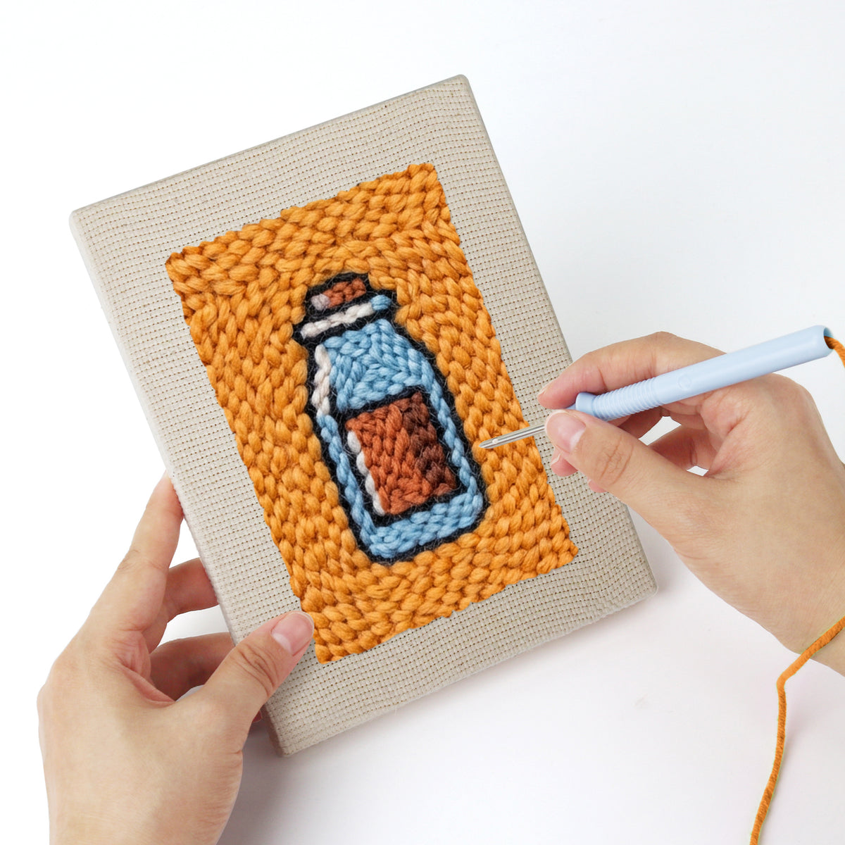Punching a Salmon Sushi Lunch mini canvas with the punch needle