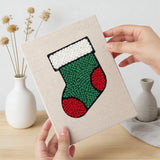 Hand holding a finished Santa and Stocking mini canvas