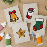 The four finished Santa and Stocking mini canvases laid out on a table