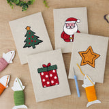 The four finished Santa and Tree mini canvases laid out on a table