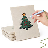 Hand punching one of the Santa and Tree mini canvases