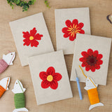The four finished Scarlet Flower Heads mini canvases laid out on a table