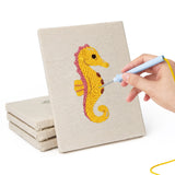 Hand punching one of the Seahorse and Crab mini canvases