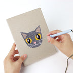 Punching a Siamese and Tuxedo mini canvas with the punch needle