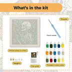 What is in the Skeleton Smelling a Flower kit: printed canvas, punch needle, threader, threads, color guide and hangers
