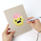Punching a Slime and Crossbones mini canvas with the punch needle