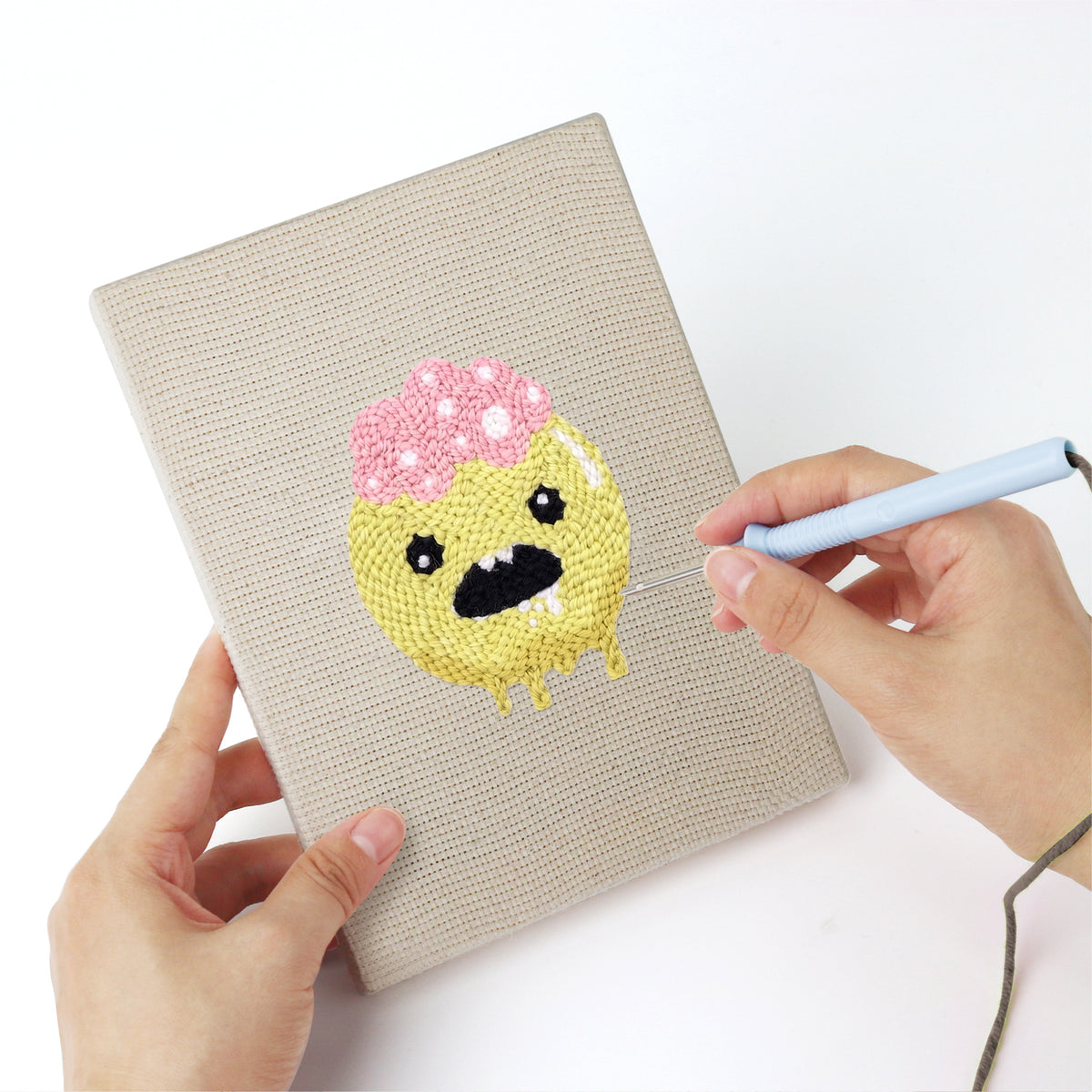 Punching a Slime and Crossbones mini canvas with the punch needle