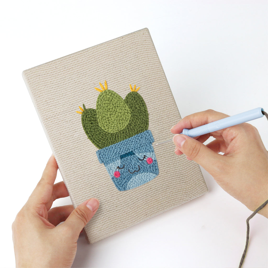 Punching a Smiling Blue Pots mini canvas with the punch needle