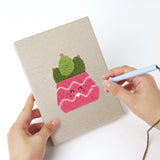 Punching a Smiling Pink Pots mini canvas with the punch needle