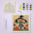 Smiling Scarecrow canvas before and after punching, with the threads and tools